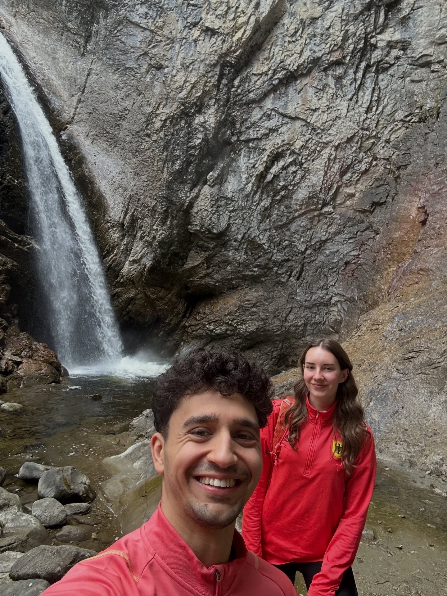 Milan Hosseini bei einem gemeinsamen Urlaubs-Selfie vor einem Wasserfall.